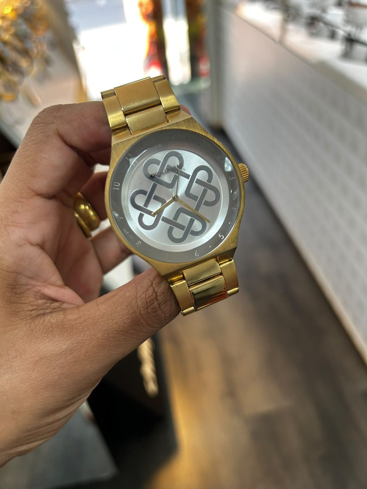 Relógio feminino dourado com pulseira de elos e fundo de coração